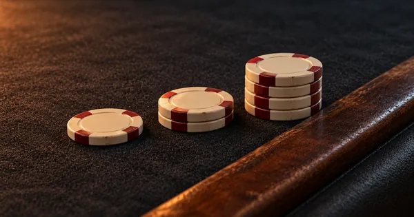 Three stacks of chips rising towards a wooden rail
